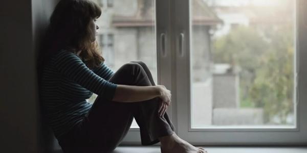 Una joven mira por la ventana 