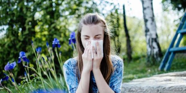  Una mujer se suena la nariz en un parque