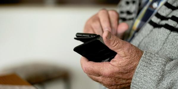 Mano de una persona mayor con un teléfono móvil