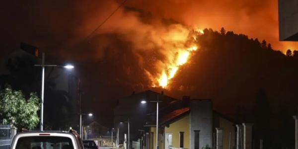 Vista de las llamas desde una zona poblada durante un incendio forestal en la provincia de Ourense.