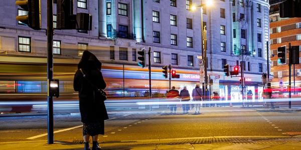 Mujer caminando sola por la ciudad en mitad de la noche