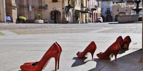 Zapatos rojos de varias mujeres simulando la violencia de género