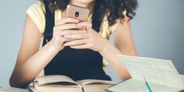 Niña con un móvil en el colegio
