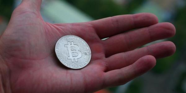 Mano de una persona con una criptomoneda