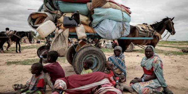 Una familia sudanesa, junto a sus pertenencias, espera junto a la frontera de Chad el pasado julio, tras huir de Darfur