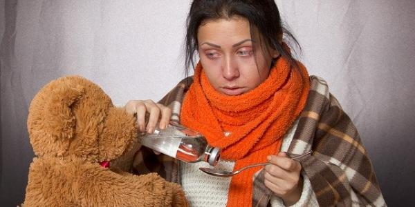 Chica tomando jarabe para mejorar las defensas con un resfriado / Pixabay