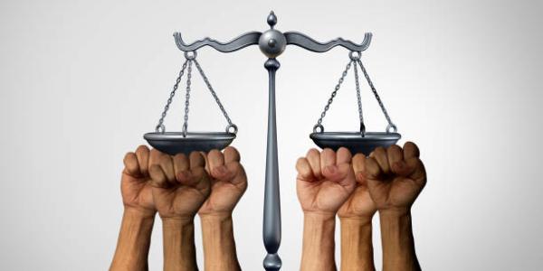 Manos sujetando una balanza de justicia