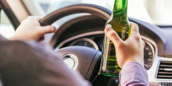 Persona conduciendo consumiendo alcohol
