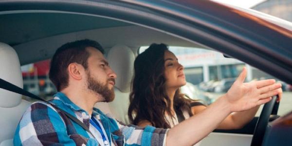 Una alumna de autoescuela con el profesor en el coche 