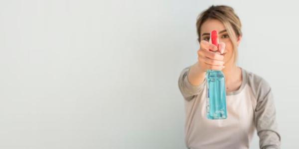 Chica con pulverizador de la limpieza