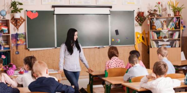 Una profesora atiende a sus alumnos en clase 