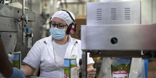 Una empleada de la cooperativa, con cascos de protección para los oídos | Foto de Dos Pinos