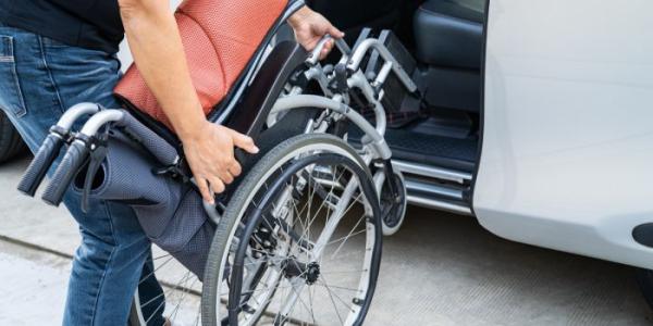 Mujer subiendo silla de ruedas a un coche