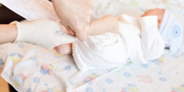 Una enfermera realiza la prueba del talón a un bebé 