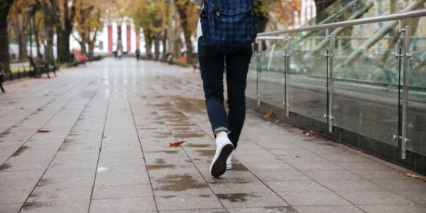 Una estudiante camina por una calle 