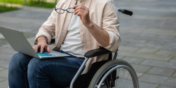Un estudiante en silla de ruedas consulta su ordenador 