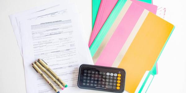 Imagen de varios papeles y una calculadora