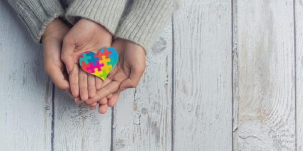 Unas manos unidas, con un dibujo de un corazón