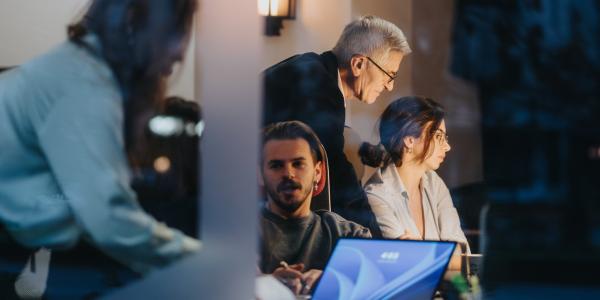 Varios trabajadores en una empresa mirando un ordenador