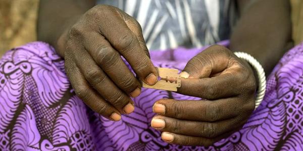Manos de una mujer de raza negra con una cuchilla