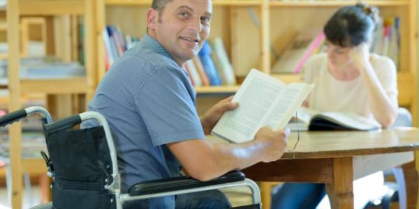 Un hombre con discapacidad, en la biblioteca de una universidad