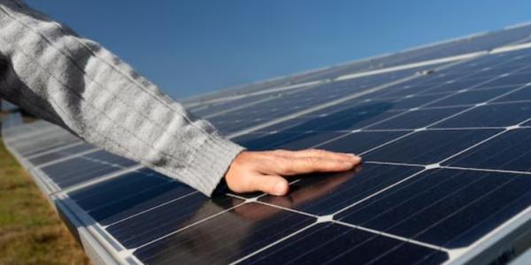 Placas solares y la mano de una persona