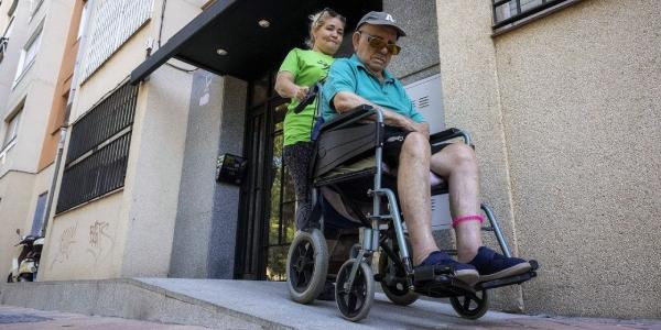 Cuidadora con un señor en silla de ruedas