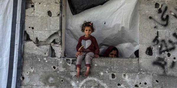 Se ve a una niña mientras palestinos examinan los escombros del edificio completamente derrumbado y buscan objetos utilizables tras un ataque aéreo llevado a cabo por el ejército israelí contra una casa perteneciente a la familia Abdulhadi en la ciudad de Khan Yunis, en el sur de la Franja de Gaza, el 6 de abril de 2025.