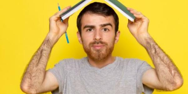 Chico con un libro en la cabeza