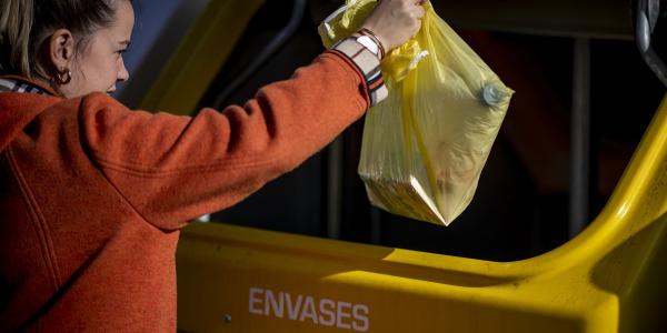 Una joven deposita residuos de envases en el contenedor amarillo | Foto de Ecoembes