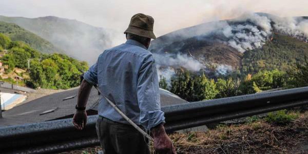 Un vecino de la aldea de Vicuña (Lugo) contempla el incendio originado en Larouco (Ourense).