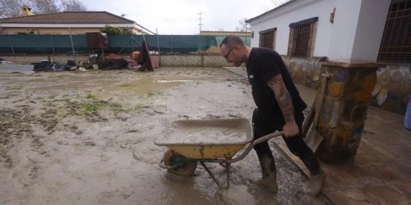 Vecinos de las parcelas próximas al río Guadalquivir limpian el lodo acumulado por el temporal