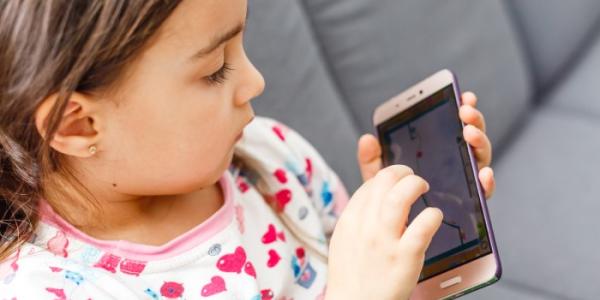 Una niña interactúa con un teléfono móvil 
