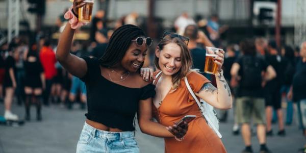 Dos chicas en un festival con cervezas en la mano