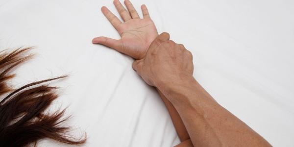 Manos de una persona ejerciendo violencia sexual