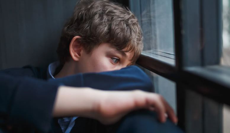 Niño mirando por una ventana