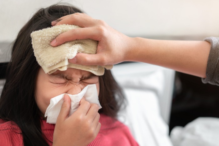 Una níña con fiebre alta y síntomas rinofaríngeos