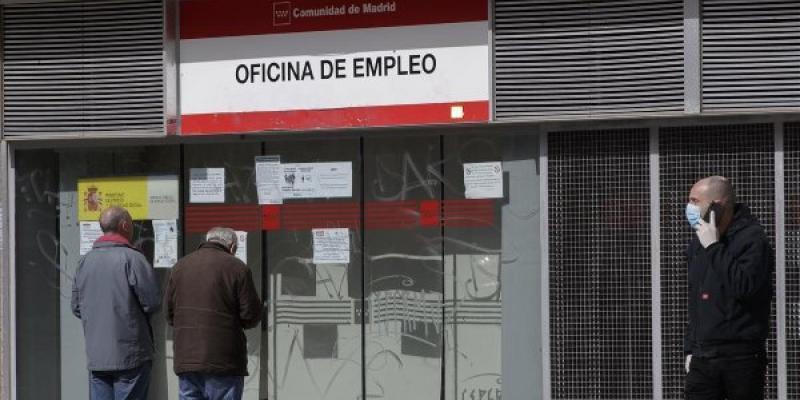 Dos personas leen los carteles de una oficina de empleo cerrada, el pasado lunes. 