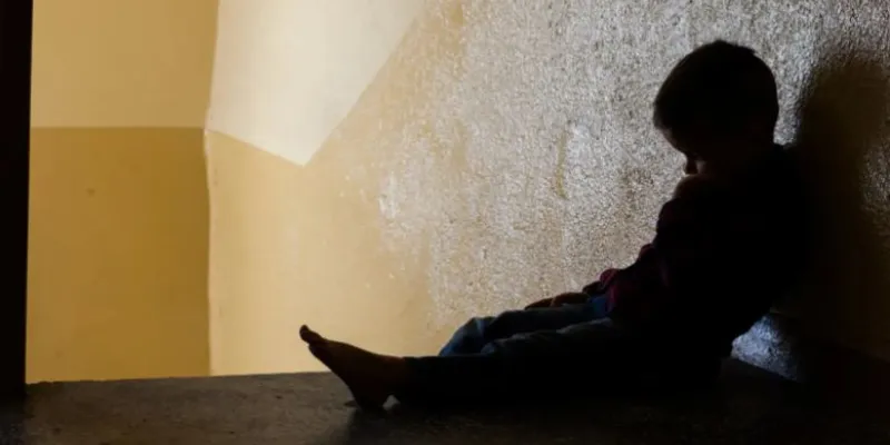 Silueta de niño contra una pared a contraluz