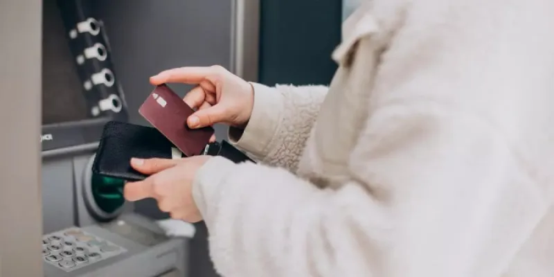 Una mujer sacando dinero del cajero 