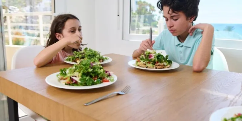 Dos menores comen comida vegetariana 