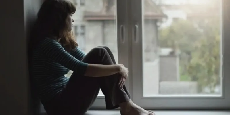 Una joven mira por la ventana 