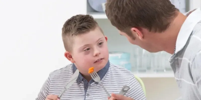 Un padre dando de comer a su hijo.