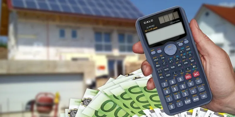 Imagen de una calculadora, billetes de 100 euros y una casa