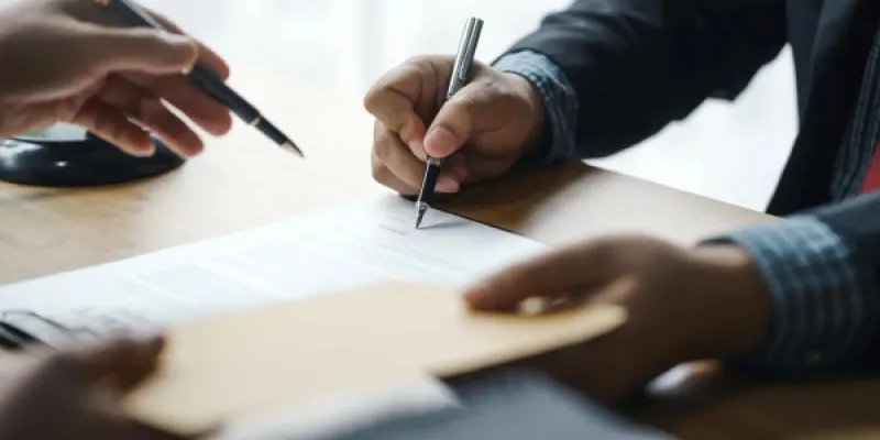 Dos trabajadores cerrando un contrato. 