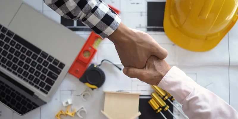 Profesionales de la construcción estrechando manos / Link to Fix