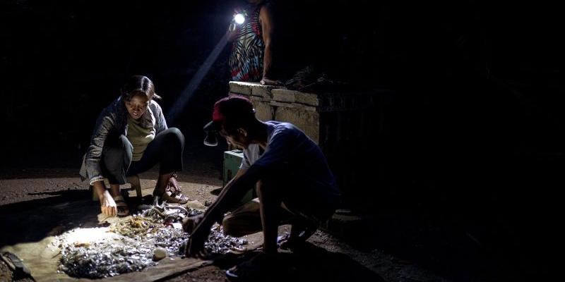 Analyn Fedelis y dos personas más clasifican su pesca. 