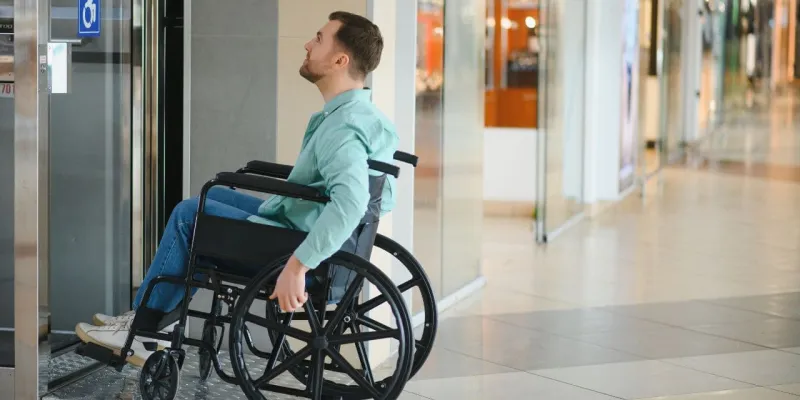 Chico en silla de ruedas subiendo una rampa accesible en Badajoz
