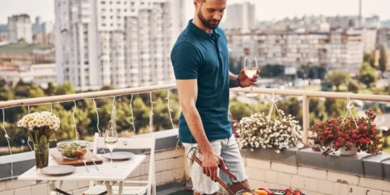 Una persona haciendo barbacoas en la terraza de su hogar