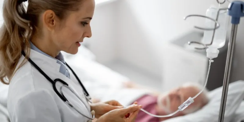 Una enfermera atiende a un paciente con la infusión intravenosa 